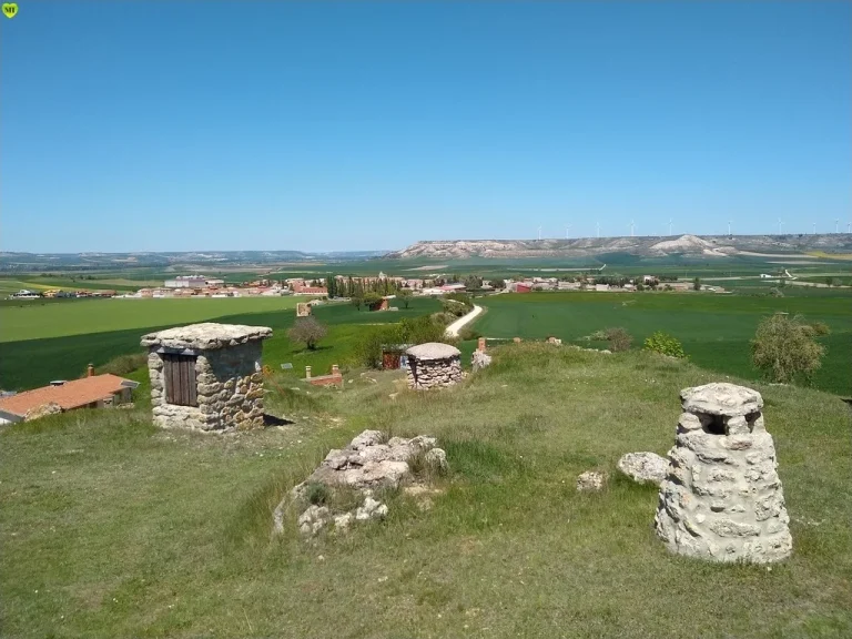 Bodegas tradicionales excavadas en la ladera, con el pueblo al fondo