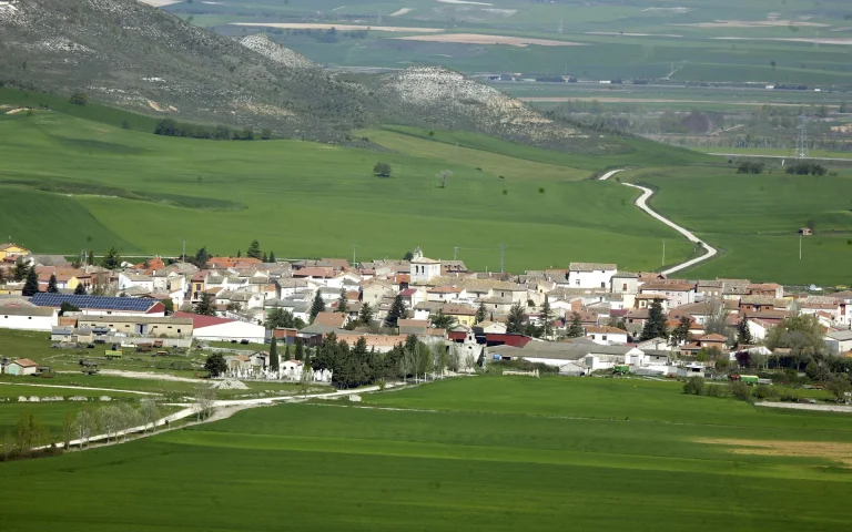 Panorámica de la vega verde con el pueblo al fondo
